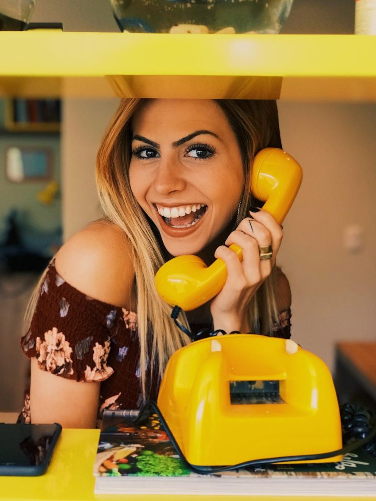gelbes Telefon mit einer Frau
